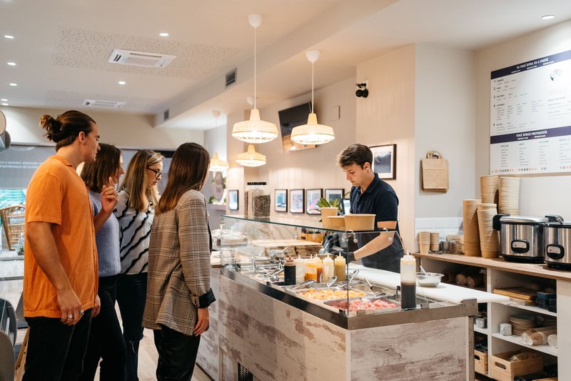 Customers ordering at the counter of a small hospitality business