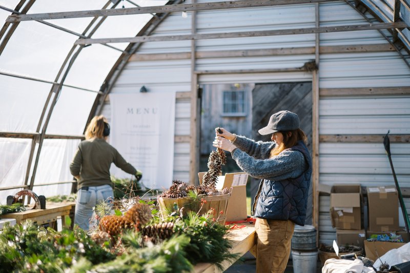 Two small-business owners working in their greenhouse workshop